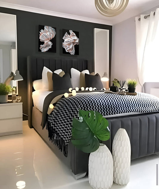 Modern bedroom with a bed, nightstands, decorative elements and two white floral paintings against the wall.