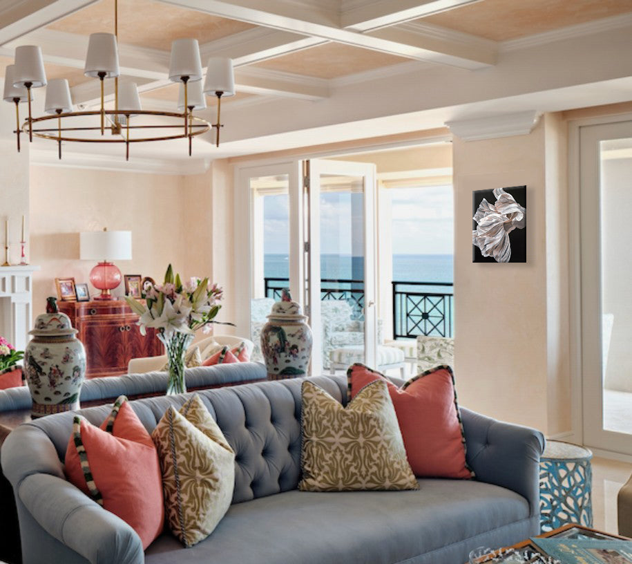 Living room with a gray sofa, colorful pillows, and a chandelier with a floral painting on the wall.