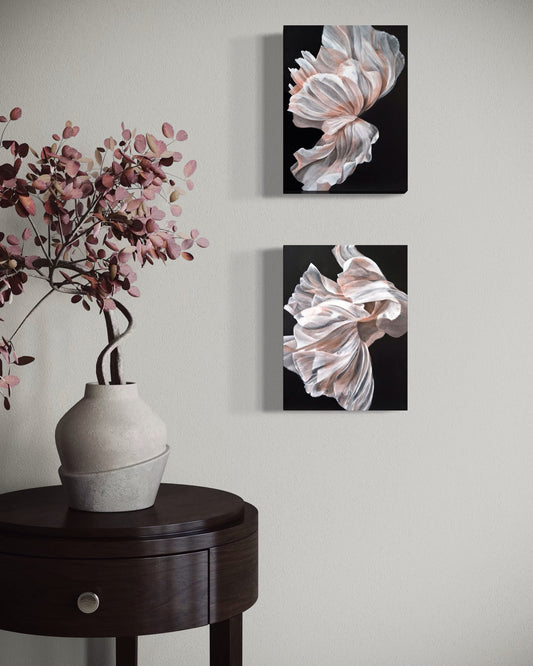 Two paintings of flowers set against grey background with a flower arrangement set on table.
