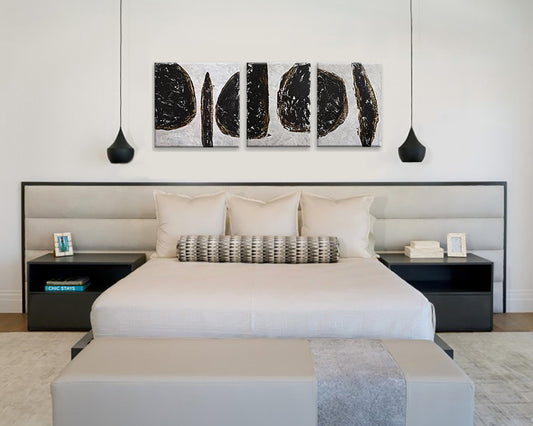 Modern bedroom with a bed, nightstands and a trio of abstract wall paintings.
