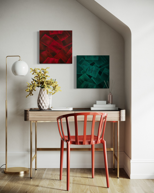Modern interior with a red chair, desk with abstract red and turquoise paintings on a white wall.